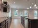 Modern kitchen featuring granite countertops, stainless steel appliances, dark cabinetry, and hardwood floors at 13 Knotty Pine Lane, Clayton, NC 27520