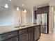 Modern kitchen features stainless steel appliances, dark cabinets, and granite countertops at 13 Knotty Pine Lane, Clayton, NC 27520