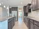 Modern kitchen featuring granite countertops, stainless steel appliances, dark cabinetry, and hardwood floors at 13 Knotty Pine Lane, Clayton, NC 27520