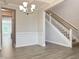 Living room with hardwood floors, white trim, a modern chandelier, and staircase to the second floor at 13 Knotty Pine Lane, Clayton, NC 27520