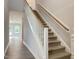 Staircase with carpeted steps, white risers and white balusters and a wooden handrail at 13 Knotty Pine Lane, Clayton, NC 27520