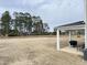 Spacious backyard featuring a large grassy area, mature trees, and a covered patio perfect for outdoor activities at 13 Knotty Pine Lane, Clayton, NC 27520