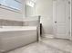 A bathroom featuring a soaking tub, tile floors, and white painted door at 13 Knotty Pine Lane, Clayton, NC 27520
