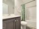 A functional bathroom with a vanity, toilet, and shower/tub combo, featuring neutral colors and a patterned shower curtain at 13 Knotty Pine Lane, Clayton, NC 27520