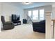 A spacious bonus room is carpeted and features natural light, furniture, and exercise equipment at 13 Knotty Pine Lane, Clayton, NC 27520