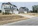 Charming two-story home with gray siding, a front porch, and a driveway leading to the garage at 13 Knotty Pine Lane, Clayton, NC 27520