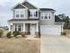 Charming two-story home with gray siding, black shutters, covered porch, and two-car garage at 13 Knotty Pine Lane, Clayton, NC 27520