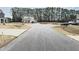 A home with well-manicured lawn and mature trees providing a serene backdrop and enhancing its curb appeal at 13 Knotty Pine Lane, Clayton, NC 27520
