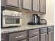 This kitchen features dark brown cabinets and granite countertops, offering plenty of space for appliances like the Keurig and toaster oven at 13 Knotty Pine Lane, Clayton, NC 27520