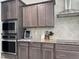 This kitchen features dark brown cabinets, stainless steel appliances, and granite countertops, perfect for the modern home at 13 Knotty Pine Lane, Clayton, NC 27520