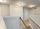 View of the landing with freshly painted white walls, wooden handrails and carpeted stairs at 13 Knotty Pine Lane, Clayton, NC 27520
