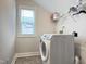 An organized laundry room features modern washer and dryer appliances, wire shelving and a window at 13 Knotty Pine Lane, Clayton, NC 27520