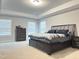 A main bedroom is spacious and features a king bed, carpet, lots of natural light, and neutral paint at 13 Knotty Pine Lane, Clayton, NC 27520