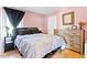 Cozy bedroom featuring a comfortable bed, wooden dresser, and soft pink walls, creating a relaxing retreat at 1314 S East St, Raleigh, NC 27601