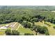 Expansive aerial view of lush greenery, a house, pond, and greenhouse at 1355 Sykes Rd, Spring Hope, NC 27882