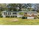 Inviting home with a green metal roof, manicured landscaping, and charming wood deck and railing at 1355 Sykes Rd, Spring Hope, NC 27882