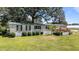 Charming home with a green metal roof, manicured landscaping, and white siding at 1355 Sykes Rd, Spring Hope, NC 27882