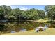 Scenic pond with a seating area near the dock, surrounded by trees at 1355 Sykes Rd, Spring Hope, NC 27882