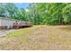 Spacious backyard featuring a charming home with a deck, offering ample space for outdoor activities and serene wooded backdrop at 141 S Creek Dr, Louisburg, NC 27549