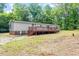 Charming home with a wooden deck in a spacious backyard, surrounded by lush trees, offering a serene and private outdoor space at 141 S Creek Dr, Louisburg, NC 27549