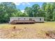 Backyard view of a charming house and deck surrounded by nature, providing a peaceful and secluded outdoor experience at 141 S Creek Dr, Louisburg, NC 27549