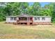 Exterior of cozy home featuring a covered porch and traditional landscaping at 141 S Creek Dr, Louisburg, NC 27549