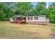Charming house with a front porch, surrounded by lush greenery and mature trees at 141 S Creek Dr, Louisburg, NC 27549