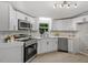 Bright kitchen features white cabinets, modern appliances, and stylish countertops at 141 S Creek Dr, Louisburg, NC 27549