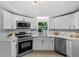 Modern kitchen with stainless steel appliances, white cabinets, and bright lighting at 141 S Creek Dr, Louisburg, NC 27549