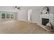 Large living room featuring a fireplace, outdoor deck access, and light-colored laminate flooring at 141 S Creek Dr, Louisburg, NC 27549