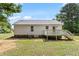 Backyard view of home featuring white siding, a small deck, and a well-maintained lawn at 1941 White Memorial Church Rd, Willow Springs, NC 27592