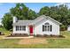 Charming single-story home boasts a red front door, neat landscaping, and classic curb appeal at 1941 White Memorial Church Rd, Willow Springs, NC 27592