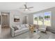 Airy living room with large windows, ceiling fan, and comfortable seating creates a welcoming atmosphere at 1941 White Memorial Church Rd, Willow Springs, NC 27592