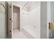 Bright bathroom featuring a tiled shower/tub, patterned wallpaper, and tiled floors at 200 Greensview Dr, Cary, NC 27518