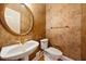 Powder room features textured wallpaper, pedestal sink, decorative fixtures, and a round mirror at 200 Greensview Dr, Cary, NC 27518