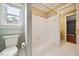 Well-lit bathroom showcasing a tiled tub, white toilet, and a neutral color scheme at 200 Greensview Dr, Cary, NC 27518