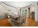 Bright dining room featuring a wooden table, light-colored chairs, hardwood floors, and stylish decor at 200 Greensview Dr, Cary, NC 27518