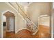 Open foyer with hardwood floors, a staircase with white railings, and arched doorways at 200 Greensview Dr, Cary, NC 27518