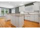 Spacious kitchen features an island, granite countertops, custom cabinetry, and hardwood floors at 200 Greensview Dr, Cary, NC 27518