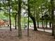 Wooded park with a view of a playground through the trees at 200 Greensview Dr, Cary, NC 27518