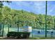 Fenced community tennis courts with lush green trees at 200 Greensview Dr, Cary, NC 27518