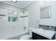 Updated bathroom with shower/tub, new vanity, tile accents, and natural light from window at 2112 Mckinney St, Burlington, NC 27217