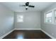 Sunlit bedroom with refinished hardwood floors, neutral walls, ceiling fan, and two windows at 2112 Mckinney St, Burlington, NC 27217