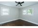 Bedroom featuring hardwood floors, neutral paint, two windows, ceiling fan, and modern trim at 2112 Mckinney St, Burlington, NC 27217