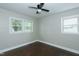 Bright bedroom featuring two windows for natural light, ceiling fan, and hardwood floors at 2112 Mckinney St, Burlington, NC 27217