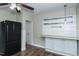 Kitchenette featuring a black refrigerator, overhead lighting and white cabinets at 2112 Mckinney St, Burlington, NC 27217