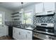 Modern kitchen with white cabinets, black appliances, and mosaic tile backsplash at 2112 Mckinney St, Burlington, NC 27217