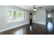 Spacious living room with refinished hardwood floors, large window, ceiling fan, and views of the entry and hall at 2112 Mckinney St, Burlington, NC 27217
