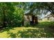A backyard shed provides extra storage space, nestled among trees on a shady lot at 2112 Mckinney St, Burlington, NC 27217