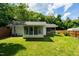 View of the spacious backyard with a well-maintained lawn and fenced-in area with both a sunroom and screened-in porch at 2821 Regent Park Ln, Burlington, NC 27217